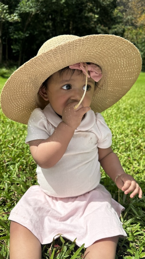 Gia in a big straw hat eating grass at Ho'omaluhia Botanical Gardens