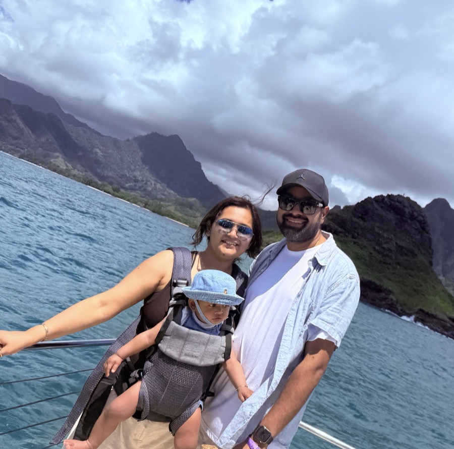 Gautam, Kanak, and Gia on the Kualoa Ranch ocean tour boat, green cliffs behind