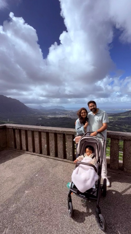 Gautam, Kanak, and Gia in her stroller at Nu'uanu Pali Lookout, windward coast and Ko'olau mountains stretching behind them
