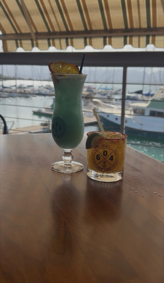 Two cocktails at Restaurant 604 with the Pearl Harbor marina behind them